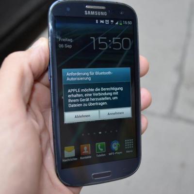 Hand hält smart phone mit apple gewinnspiel bluetooth verbindung