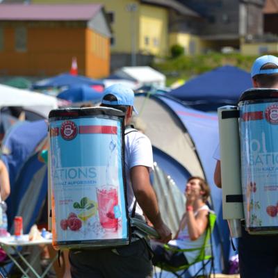 2 Promoter in Fußgängerzzone mit Tekanne Poster auf Rucksack