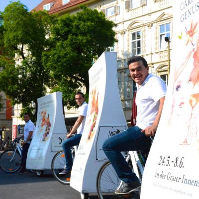 Kamboucha City Light Poster auf Rädern mit lachendem Radfahrer