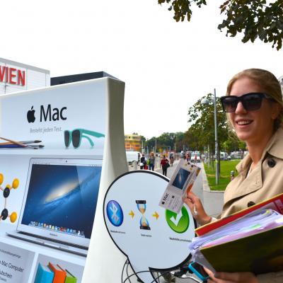 iMac Werbung als mobiles City Light an Fahrrad in der Innenstadt mit Passantin