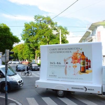 2 mobile Plakate auf Kleinlaster weiss mit Werbung für Carpe Diem in Stadtverkehr
