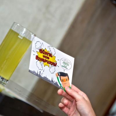 Postkarten mit Werbung für Bezirkszeitung in einer Hand gehalten in Bar Restaurant