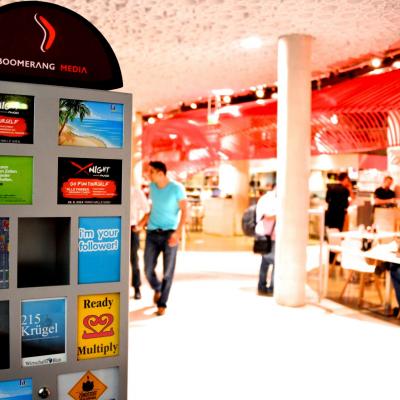 Werbepostkartenständer in Gastronomiebetrieb mit hellem roten Ambiente