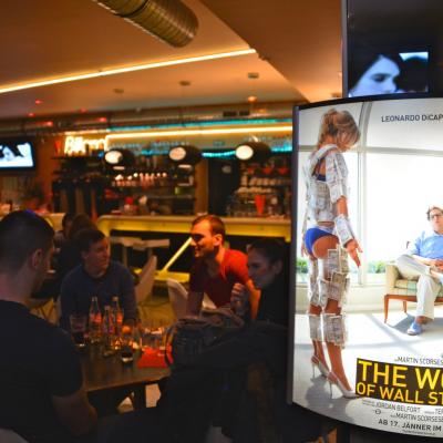 Beleuchtetes Werbe-Plakat in dämmriger schicker Bar