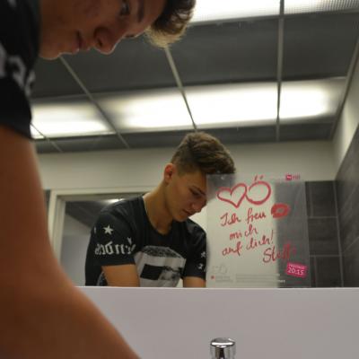 Werbung von Puls 4 als Aufkleber auf einem Spiegel in einer Restaurant Toilette