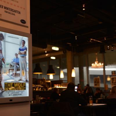 Beleuchtetes Werbe-Plakat in dämmriger schicker Bar