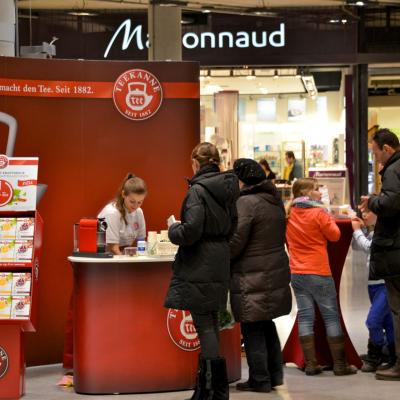 ein roter teekanne promotionsstand in einer shopping mall mit passanten