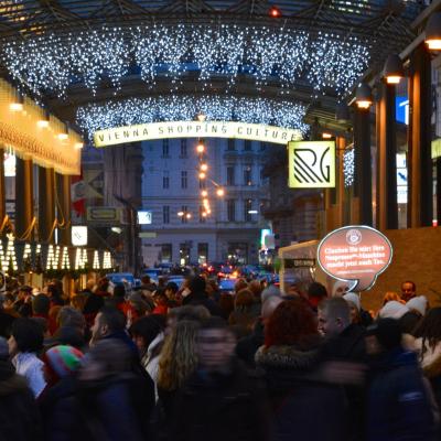 Promoter mit beleuchteter oranger Sprechblase in City bei Dämmerung