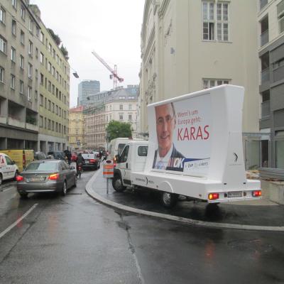 16 Bogen Plakat auf weissem Auto mit Wahl-Werbung für ÖVP im Großstadtverkehr