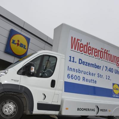 16 Bogen Plakat auf weissem Auto mit Werbung für LIDL im Großstadtverkehr