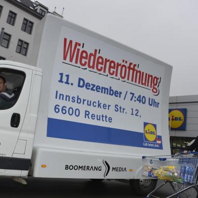 16 Bogen Plakat auf weissem Auto mit Werbung für LIDL im Großstadtverkehr