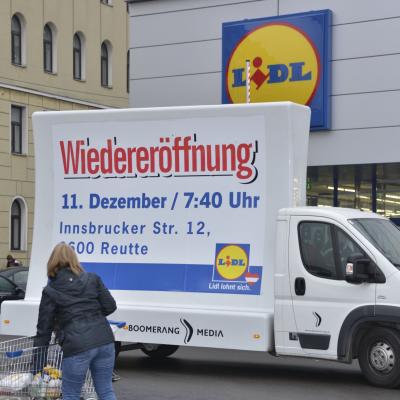 16 Bogen Plakat auf weissem Auto mit Werbung für LIDL im Großstadtverkehr