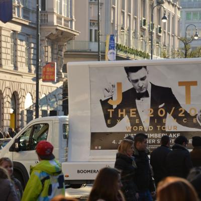 16 Bogen Plakat auf weissem Auto mit Werbung für Justin Timberlake Konzert im Großstadtverkehr