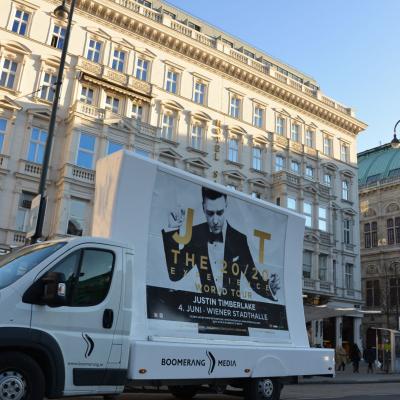 16 Bogen Plakat auf weissem Auto mit Werbung für Justin Timberlake Konzert im Großstadtverkehr