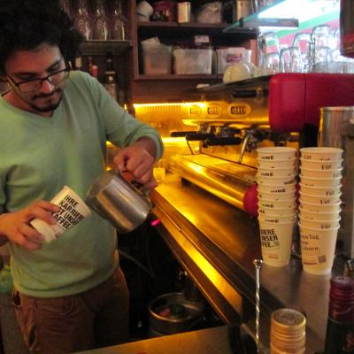 Kaffeebecher Kaffee zum Mitnehmen weiss mit Werbung in Bar wird aufgefüllt von Verkäufer