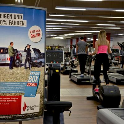 beleuchtetes Poster in Kardio Bereich im Fitnessstudio mit BAWAG Werbung