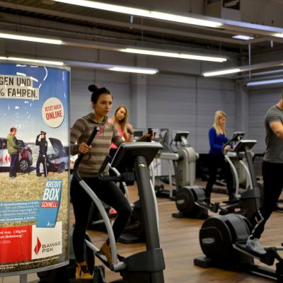 beleuchtetes Poster in Kardio Bereich im Fitnessstudio mit BAWAG Werbung