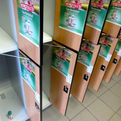 Umkleidekabinen in Fitenss Studio mit grünen Werbepostern auf der Innenseite der Türen