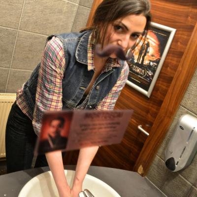 Frau wäscht sich die Hände in Restaurant Toilette und sieht Spiegel mit Werbe Aufkleber