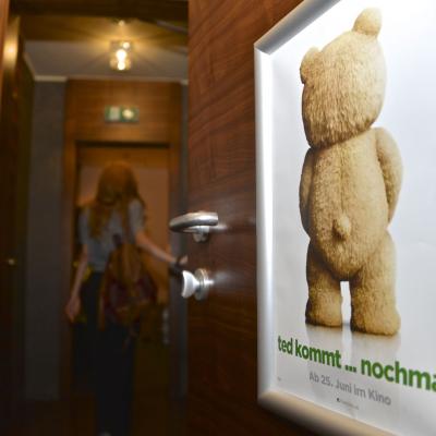 Filmwerbung in Restaurant Toilette mit Alurahmen auf brauner Wand