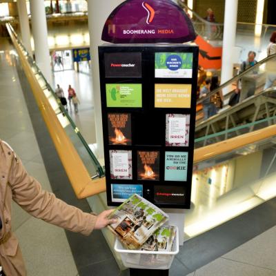 IKEA Katalog liegt in durchsichtigem Korb an Postkartenständer in modernem Bar Restaurant