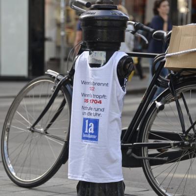 weisses Werbe T-Shirt für Installateure ist über Hydrant gezogen in Innenstadt