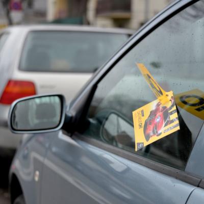 Gelbe Werbe-PostKarte steckt an Autofenster