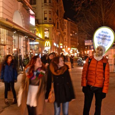 Promotor mit Sprechblase und Werbung über dem Kopf in Passantenmenge