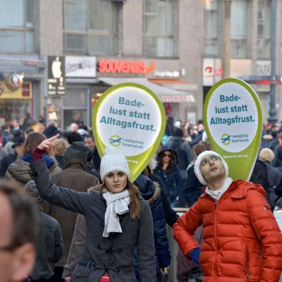 Promotor mit Sprechblase und Werbung über dem Kopf in Passantenmenge