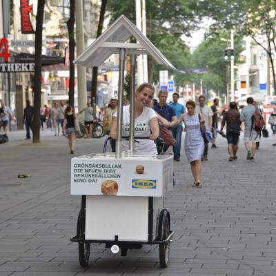Weisses Promotion Dreirad mit Dach und Promotoren in Innenstadt verteilen IKEA Fleischbällchen