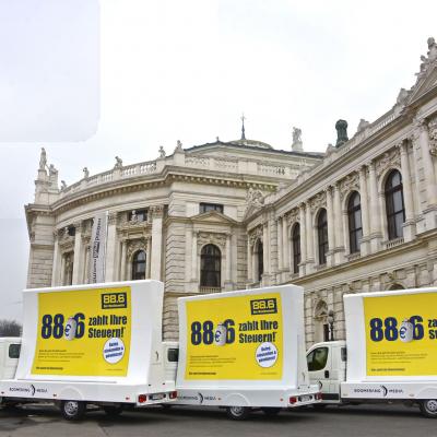 16 Bogen Plakat auf weissem Auto mit gelber Werbung für Radio 88,6 im Großstadtverkehr