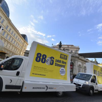 16 Bogen Plakat auf weissem Auto mit gelber Werbung für Radio 88,6 im Großstadtverkehr