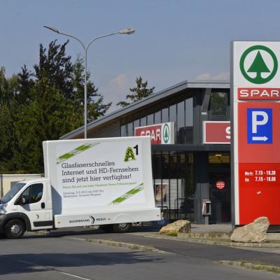 16 Bogen Plakat auf weissem Auto mit Werbung für A1 Telekom im Großstadtverkehr