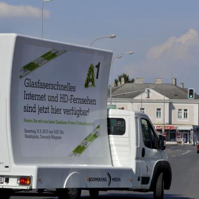16 Bogen Plakat auf weissem Auto mit Werbung für A1 Telekom im Großstadtverkehr