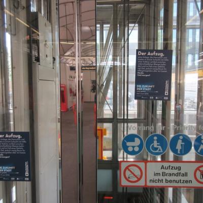 Durchsichtiger Werbeaufkleber für technisches Museum auf gläsernem Aufzug