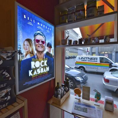 Beleuchtetes Werbe-Plakat in schicker Bar mit großer Glasfront