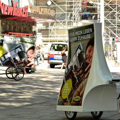 City Lights mit IKEA Werbung an Fahrrad vor Passanten in Fußgängerzone