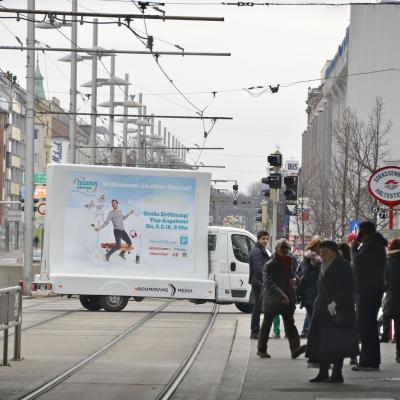 16 Bogen Plakat auf weissem Auto mit Werbung für HUMA 11 im Großstadtverkehr