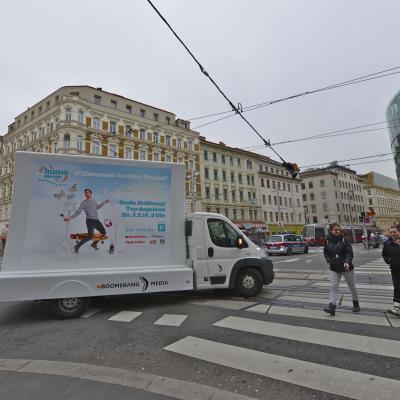 16 Bogen Plakat auf weissem Auto mit Werbung für HUMA 11 im Großstadtverkehr