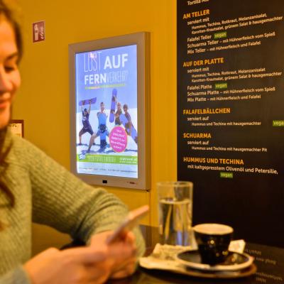 Beleuchtetes Werbe-Plakat in dämmriger schicker Bar