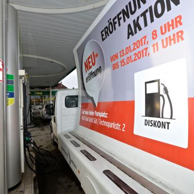 16 Bogen Plakat auf weissem Auto mit Werbung für OMV Diskont auf Konkurrenz Tankstelle