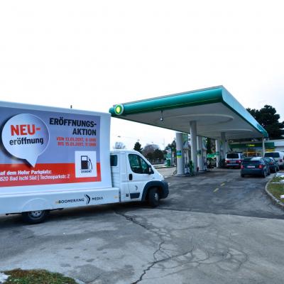 16 Bogen Plakat auf weissem Auto mit Werbung für OMV Diskont auf Konkurrenz Tankstelle