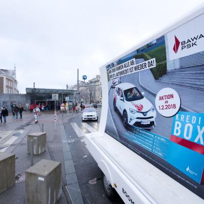 16 Bogen Plakat auf weissem Auto mit Werbung für BAWAG im Großstadtverkehr
