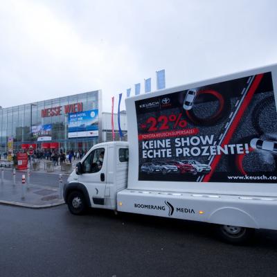 16 Bogen Plakat auf weissem Auto mit Werbung für Toyota im Großstadtverkehr