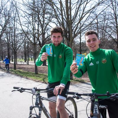 Sportler im Prater erhalten von Promotoren in silbernen Overalls Produktproben von Magnofit