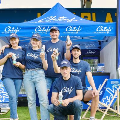 Foto von Promotor:innen vor einem Chiefs Stand